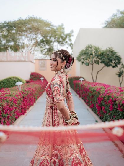 The bride looks serene and beautiful in this outdoor shot. Her makeup is fresh and radiant, perfect for a daytime wedding ceremony.