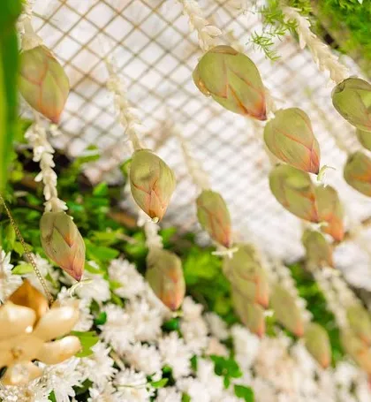 A detailed view of the hanging lotus buds and jasmine strings. These traditional elements add fragrance and a delicate, handcrafted feel to our decor for cultural events.