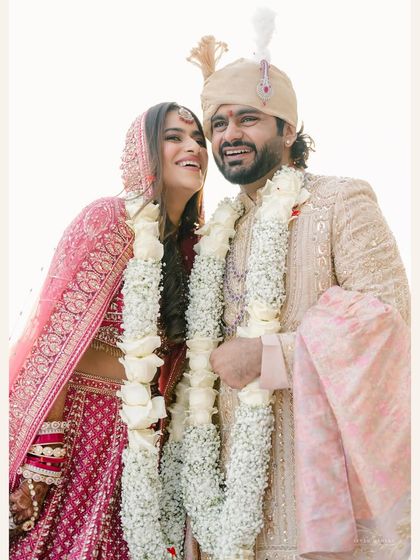 Pure joy after the ceremony. The garlands, the smiles, the embrace, it all comes together in a perfect portrait of a newly married couple.