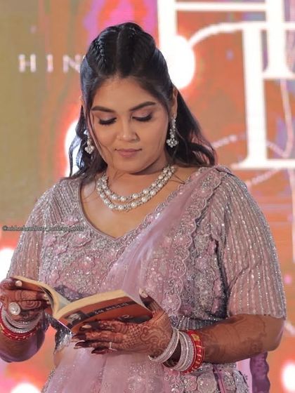 A quiet moment during the sangeet. Her makeup is soft and elegant, with a focus on a flawless complexion and subtle shimmer.