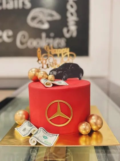 A bold red Mercedes-themed cake. This luxurious design features the iconic logo, edible money, and a car topper for a lavish celebration.