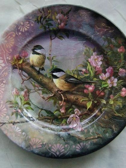 This beautifully decorated plate was created using decoupage, the art of applying paper cutouts to a surface. The delicate bird and floral design gives it a classic, painted look.