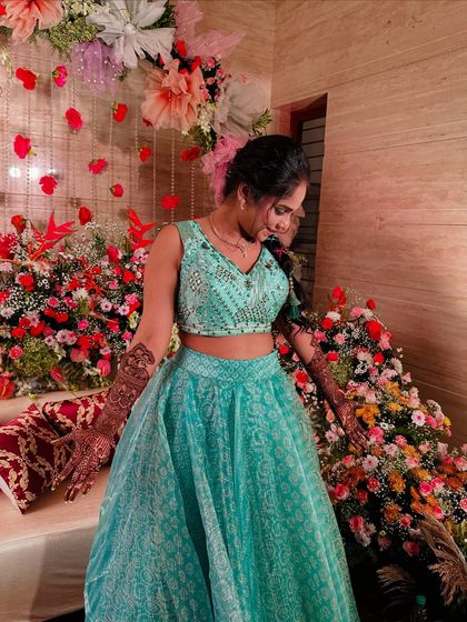 The bride in her element, surrounded by flowers, her mehndi adding to the festive look.