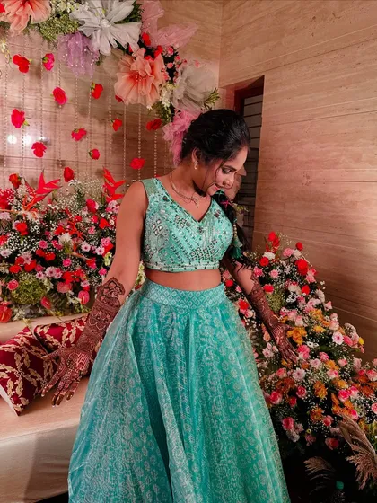 A full-length shot of a happy client in her festive lehenga, her beautiful mehndi completing the celebratory look.