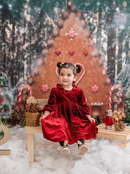 A perfect Christmas card photo. This little girl in her festive red dress is the picture of holiday cheer.