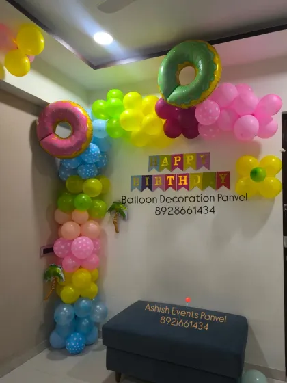 A fun and colorful birthday corner decoration. This arrangement uses a variety of bright colors and donut-shaped foil balloons for a playful look.