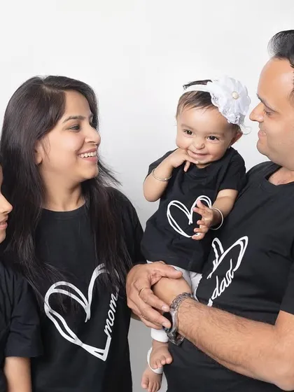 A candid moment of interaction between all four family members. The baby's little smile is just adorable.