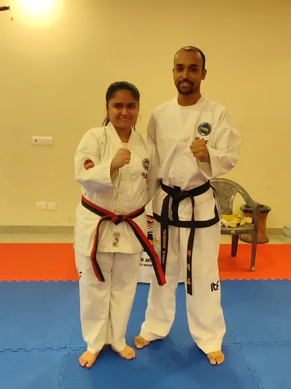 A student receives her red-stripe belt, marking her entry into the advanced stages of Taekwon-Do.