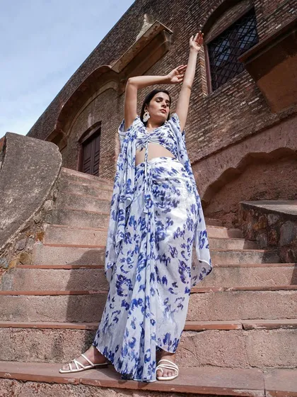 A dynamic pose showcasing the flow and design of a floral print dhoti-style outfit with a cape.