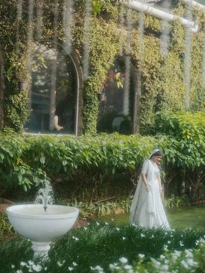 A serene bridal portrait in a lush garden. We use the natural environment and architectural elements to create beautiful, composed shots.
