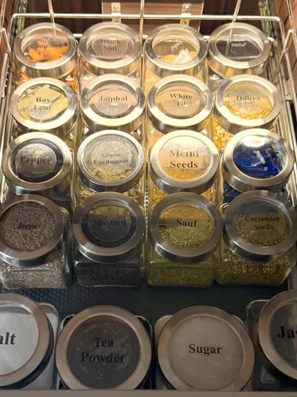This is how we tackle the spice drawer. By decanting into uniform, clearly labeled jars, we make every masala and herb easy to identify, ensuring your cooking process is always smooth and efficient.