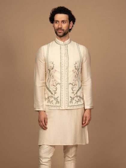 This embroidered Jawahar jacket in a soft ivory hue whispers of heritage. The delicate floral embroidery is a story in itself, crafted from luxurious fabric for a feeling of pure sophistication.