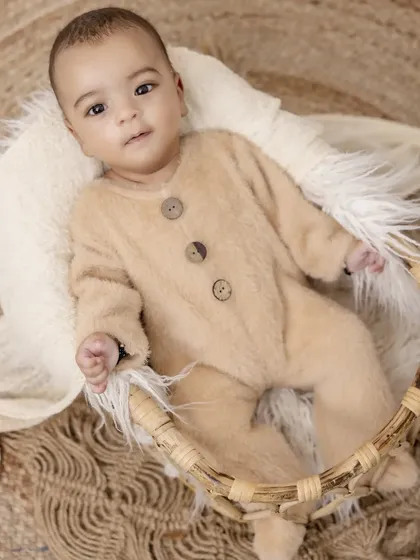 Snug as a bug in a basket. This little one is warm and comfortable in a soft fleece onesie, perfectly posed in a woven basket for a timeless and gentle baby portrait.