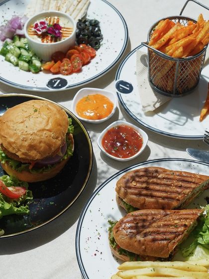 This complete lunch spread shows the variety I offer. From the hearty burger and fries to the lighter hummus platter and panini, there is something for every appetite.