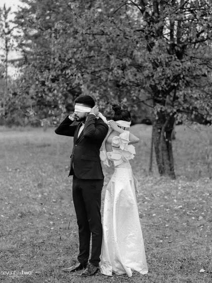 Whispering secrets, or perhaps just feeling the presence of the other. This blindfolded concept in black and white strips away all distractions, focusing purely on their connection.
