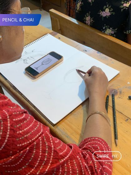 A student sketches a wine glass, preparing for a still life painting. This shows the diverse subjects we cover in our classes.