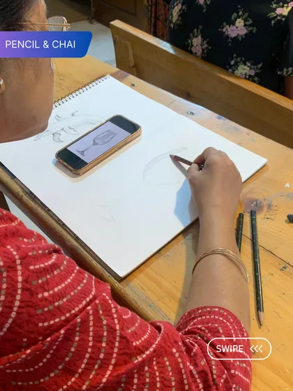 A student sketches a wine glass, preparing for a still life painting. This shows the diverse subjects we cover in our classes.