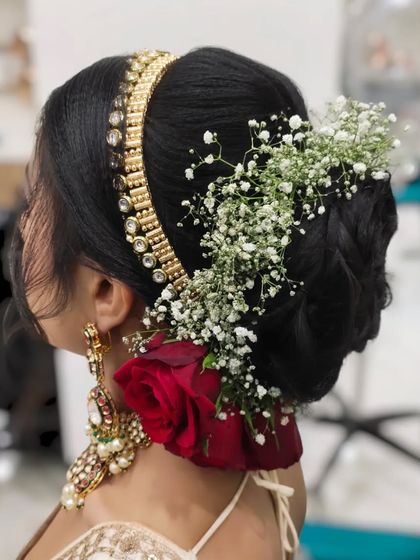 A side view of the classic floral bun, showing how the hair is neatly tucked and decorated with roses and a traditional hair accessory.