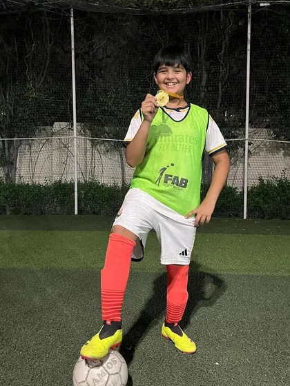 A player proudly shows off his medal. We believe in recognizing and celebrating every achievement, big or small.