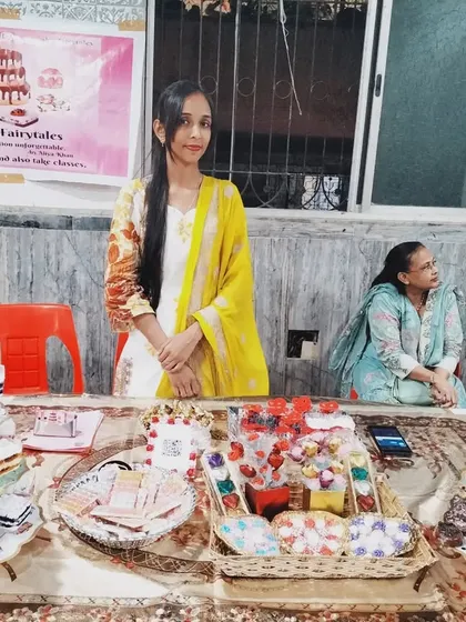 This is me, Aliya, at one of my exhibition stalls. I am a home baker and I pour all my love into The Cake Fairytales. I am so grateful for every chance to share my creations with you.