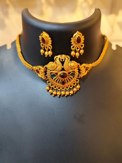 A beautiful choker with a peacock pendant and multi-colored stones.