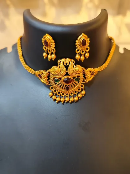 A beautiful choker with a peacock pendant and multi-colored stones.