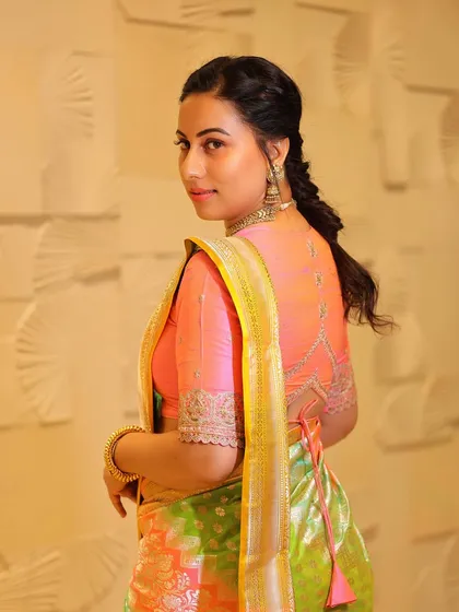A back view of Dr. Shruthi, showing the beautiful embroidery on her blouse that complements the vibrant saree.