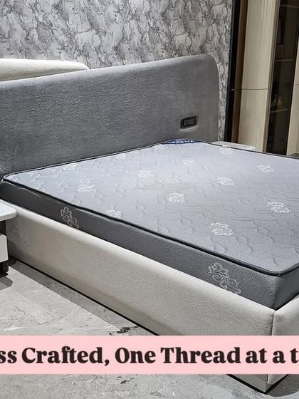 This modern bed design features a unique asymmetrical headboard in two different fabrics. It also includes an integrated floating nightstand with a marble top and built-in charging sockets for convenience.