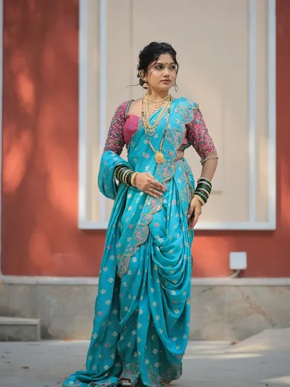 A full-length shot showing the elegant drape of the turquoise Nauvari saree. The style is traditional yet looks incredibly graceful and modern.