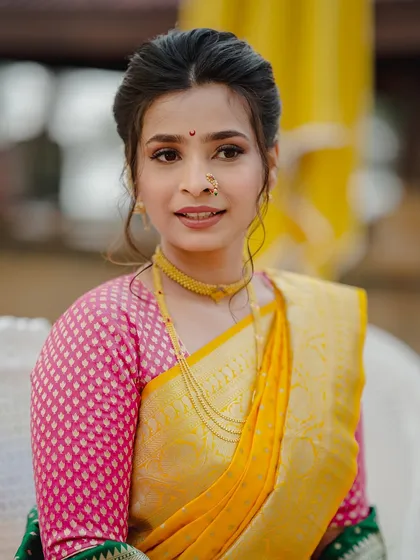 A poised and elegant portrait. The makeup is soft and understated, allowing the rich colors of her Paithani saree and her traditional jewelry to stand out.