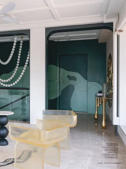 A magazine feature showcasing the Evelyn lounge. The image highlights the custom resin chairs, the sculptural side tables, and the dramatic pearl necklace chandelier, all elements of our bespoke design approach.