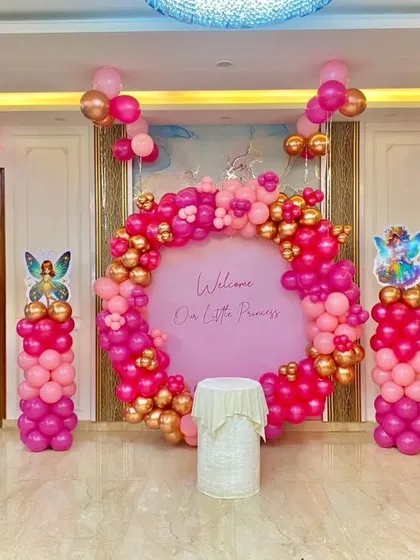 A wider view of the princess welcome home party, showing how the balloon ring and pillars fit perfectly within a modern apartment living room.
