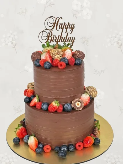 A two-tiered chocolate lover's dream. This birthday cake is covered in smooth chocolate frosting and decorated with fresh berries and Ferrero Rocher chocolates.