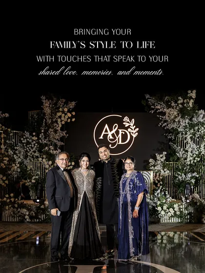 Bringing a family's style to life for an evening of celebration. This portrait shows the couple with the groom's parents at the reception. The mother's deep blue embroidered outfit and the father's classic suit perfectly complement the couple's shimmering monochrome ensembles.