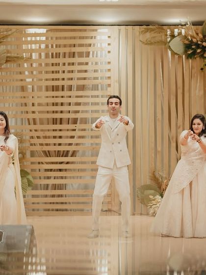 The groom and his family in the middle of a fun performance, with the elegant stage decor providing the perfect backdrop.