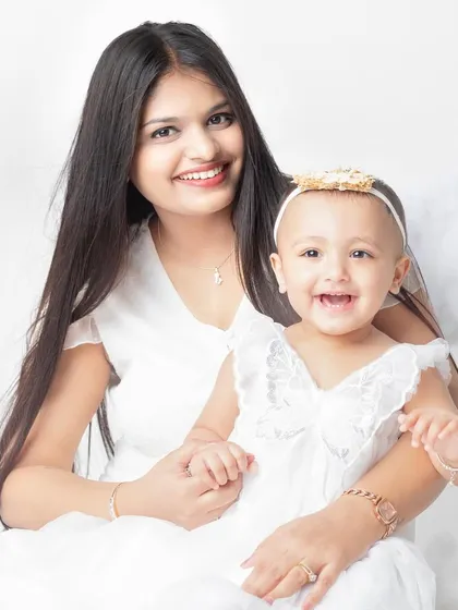 A mother and her little angel. The coordinating white outfits and happy smiles make this a heavenly portrait.