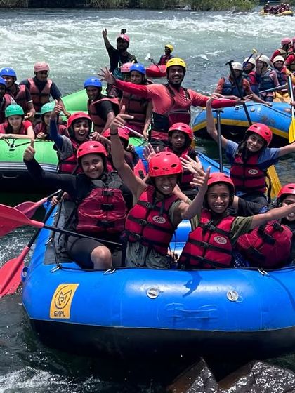 Multiple rafts filled with enthusiastic campers celebrate on the water in Dandeli. This image captures the large scale and high energy of our summer camps.