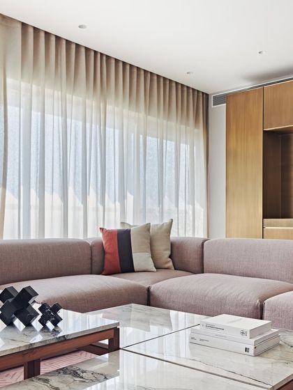 A detail shot of the comfortable sectional sofa in the Maximum City Duplex. The mix of striped and solid cushions adds a subtle visual interest to the space.