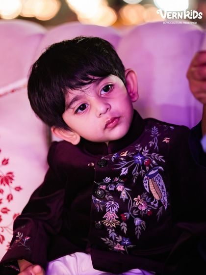A candid shot of two brothers in their matching custom Indo-western outfits. The deep burgundy velvet and intricate embroidery make these pieces truly special.