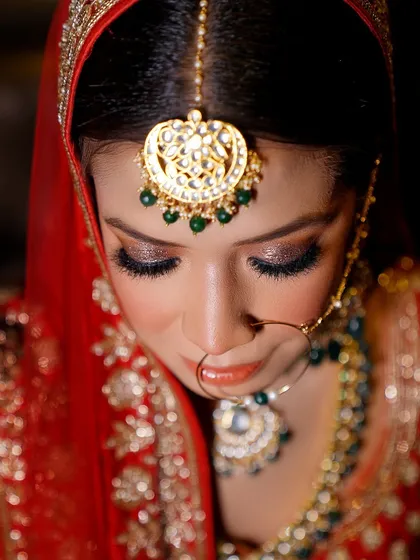 An artistic top-down shot of the bride. This angle beautifully showcases her maang tikka, eye makeup, and the top of her lehenga.