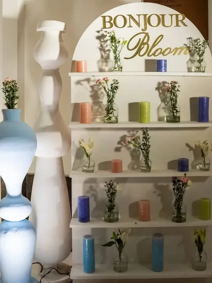 The 'Bonjour Bloom' corner, a modern take on a flower display with clean white shelves, minimalist vases, and colorful candles.