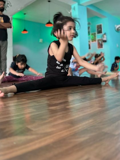 Another student confidently holding a center split. The ability to maintain this pose comes from building strength in the hips and core, not just passive stretching.