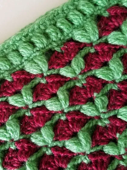 Close-up of the green and maroon version of the Cardamom Blossoms stitch.