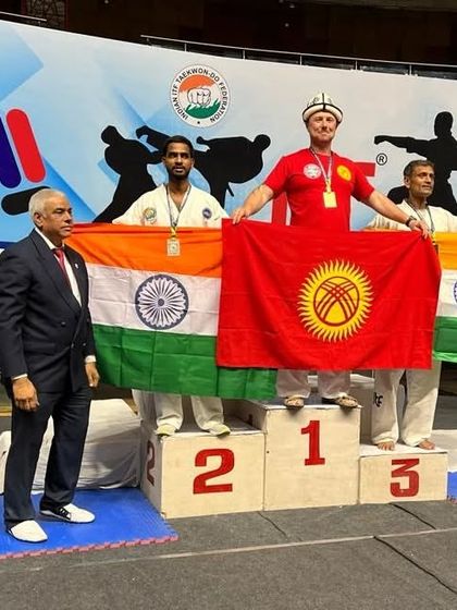Soumendra Rajpoot on the podium after winning silver at the Asian Championship, flanked by international competitors.