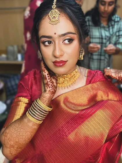 A behind-the-scenes shot of the bride getting ready, her makeup looking soft and beautiful.