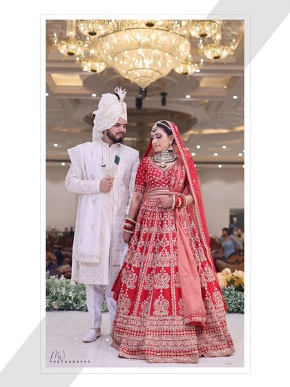 A full-length couple portrait, showcasing their coordinated outfits and the overall grandeur of the wedding.