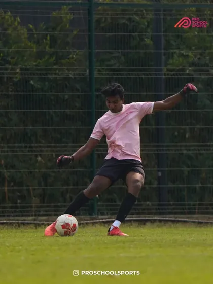 A coach demonstrates proper kicking technique during a practice session.