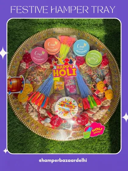 Another view of our grand Holi hamper tray, all wrapped up and ready to go. The golden tray is filled to the brim with colorful treats and festive items.