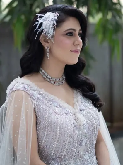 The complete look, showing how the wavy hair and cape-style gown create a dramatic and elegant effect. This is a perfect hairstyle for a modern reception or engagement party.