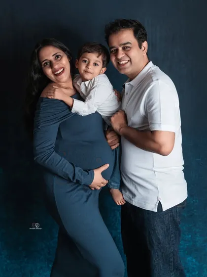 A slightly different take from the same session, capturing the genuine laughter and joy of the whole family as they anticipate their new arrival.